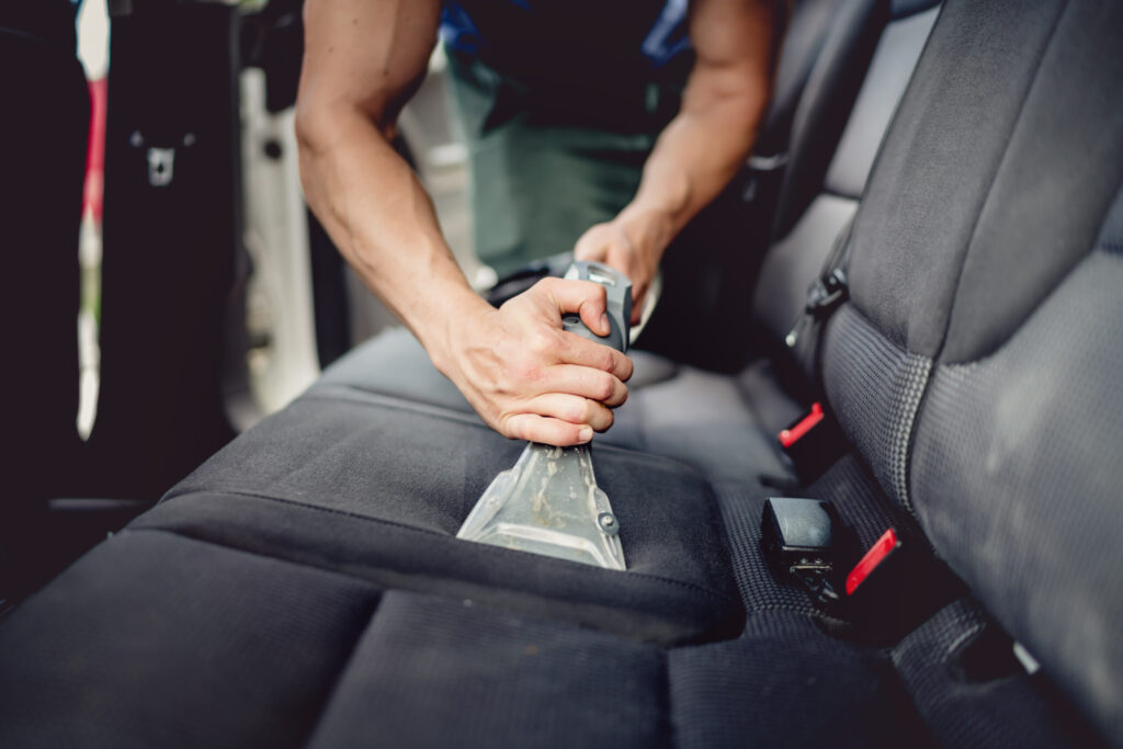 Close up details of car detailing - Cleaning and vacuuming car interior
