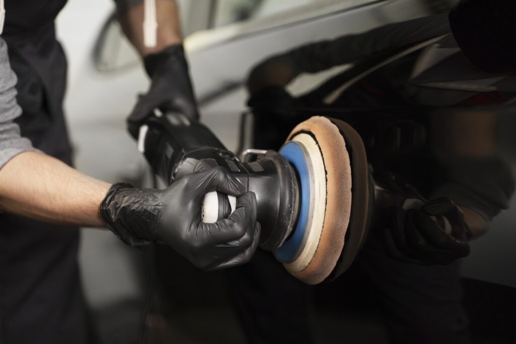 man polishing a black car as an auto detailing service