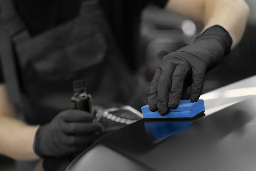 Close up of a car waxing and coating process on a black car at QC Elite Detailing
